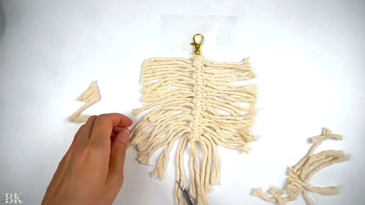 Combing out the macrame fringe to prepare for trimming into a feather shape