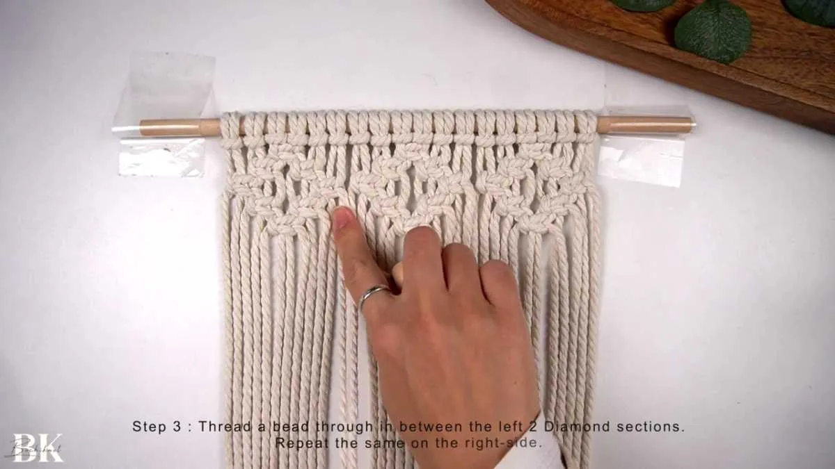 Threading wooden beads between the macrame diamond sections